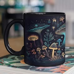 a black coffee mug sitting on top of a table next to a pile of books