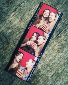 two people taking pictures with their cell phones on the cover of a book that is laying on top of a wooden table