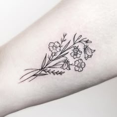 a small flower tattoo on the arm