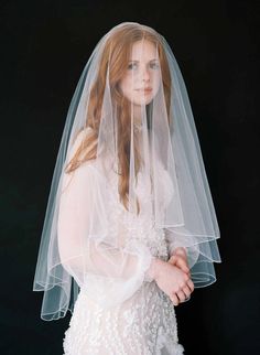 a woman wearing a white veil and dress