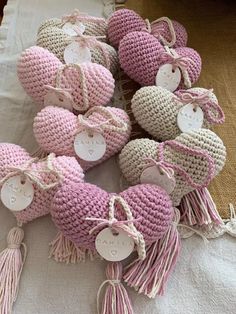 crocheted hearts with tassels and tags are arranged on a white tablecloth