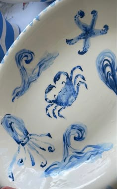 a blue and white plate with an image of two crabs on the inside of it