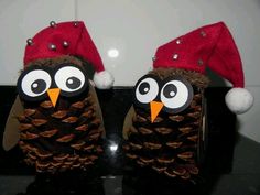 two pine cone owls wearing christmas hats