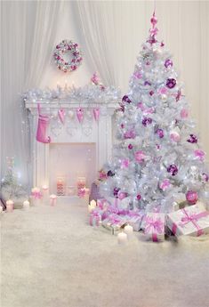 a white christmas tree in front of a fireplace with pink and silver decorations on it