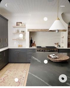 an image of a modern kitchen setting with black countertops and white appliances, including a bowl on the island