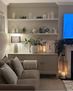 a living room filled with furniture and a flat screen tv mounted on the wall above a fireplace