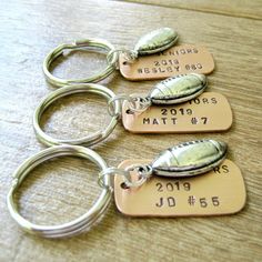 four personalized metal key chains on a table