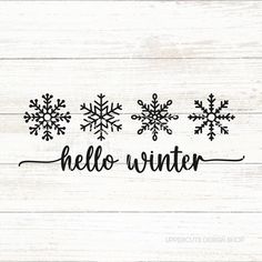 the word hello winter written in black ink on white wood planks with snowflakes