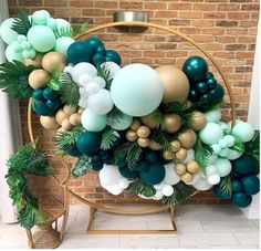 the balloon arch is decorated with green, gold and white balloons