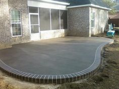 a concrete patio in front of a brick house