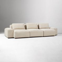 a white couch sitting on top of a white floor