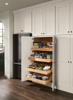 an organized kitchen with white cabinets and drawers