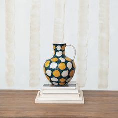 blue jug with white and yellow dots set on a stack of books on a table. All Natural Cleaners, Woodland Christmas, Candle Tray, Creative Co Op, Christmas Tablescapes, Linen Spray, Jewelry Tree, Glass House, Pillow Gift