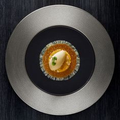 a plate with some kind of food on it and gold trim around the edge,