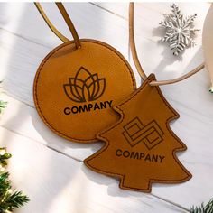 two leather tags with the words company and a christmas tree on them, hanging from a string