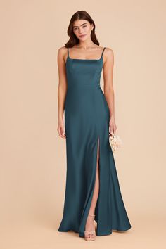 a woman in a long green dress with a slit down the side and one leg