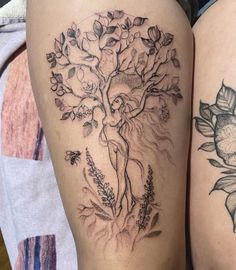 two women with tattoos on their legs, one has a tree and the other has flowers