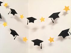 graduation decorations made out of paper with yellow stars on the bottom and black caps in the middle