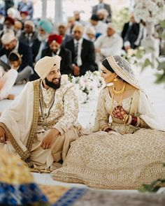 a man and woman sitting next to each other in front of a group of people