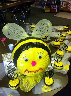 a group of bees sitting on top of each other in front of some cups and spoons