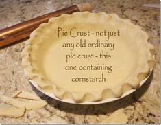 a pie sitting on top of a counter next to a wooden spatula with writing on it