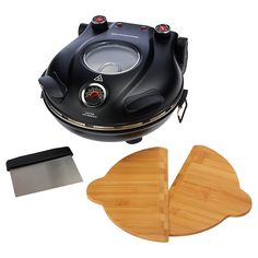 an electric cooker with two wooden paddles and a cutting board next to it