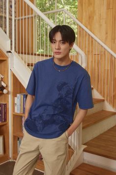 a young man standing in front of a stair case