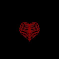 a red heart shaped object on a black background