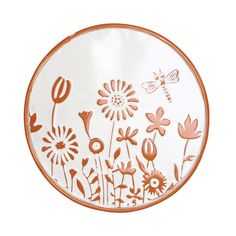 an orange and white plate with flowers and a dragonfly on the side, sitting in front of a white background