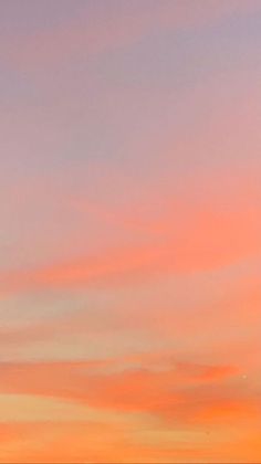 an airplane is flying in the sky at sunset or sunrise with pink and orange clouds