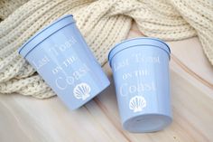 two blue cups sitting on top of a wooden table