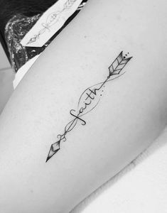 a woman's leg with an arrow tattoo on it