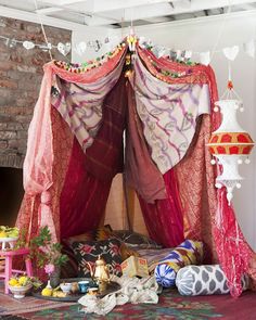 an image of a bed that has been decorated with pink and red fabric on it