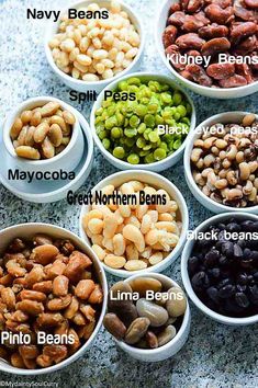 seven bowls filled with different types of nuts and beans, labeled in the names below