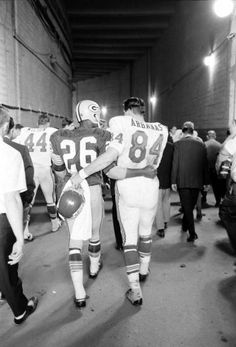 two football players are walking down the tunnel