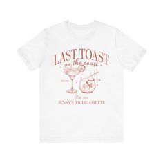 a white t - shirt that says last toast on the coast with an image of a cocktail