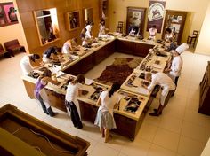 a group of people standing around a table covered in lots of different types of items