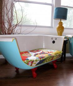 an old fashioned bathtub is painted bright blue and has colorful flowers on the seat