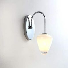 a white wall light mounted on the side of a wall next to a lamp shade