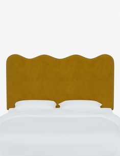 an upholstered headboard on a bed with white sheets and pillows, against a plain background