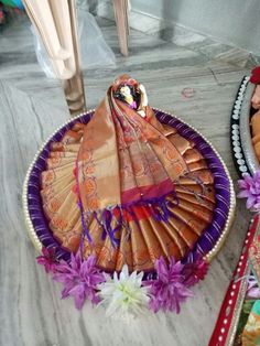 a decorative fan sitting on top of a table next to other plates with food in it