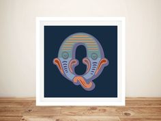 an art print with the letter o in blue and orange colors on a wood floor