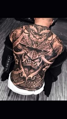 the back of a man's body covered in tattoos