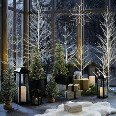 christmas trees and presents in front of a large window with snow on the windowsill