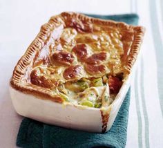 a close up of a casserole dish on a blue napkin with a fork