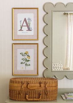 a suitcase sitting on top of a white table next to a mirror and framed pictures