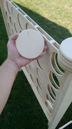 a person holding a frisbee in their hand near a wooden bench on the grass