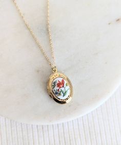 This small and dainty little gold plated locket features a sweet red-orange tulip flower vintage glass cabochon. It opens with the hinge at the side and there is space inside for a photo, secret message or little hand stamped initial. Suspended from either a gold plated chain with lobster clasp or a 14k gold filled chain with spring clasp close. Personalise for the perfect gift with a little hand stamped tag (fits one single Initial) https://etsy.me/33z0KEa or a Crystal birthstone: https://etsy.me/2HxFczT Add a Hand Stamped Initial Inside (pic 5) https://etsy.me/3BPkx0b Handmade with LOVE in Australia 🐨 | ADDITIONAL INFORMATION | Gold filled jewellery is an affordable alternative to solid gold that is durable, tarnish resistant and wearable for people with sensitive skin. Please allow 1-4 Cute Etsy Jewelry, Gifts To Give To Your Best Friend, Flower Locket Necklace, Simple Gold Jewelry Aesthetic, Gifts Under $10, Gold Stacked Necklaces, Mil Gifts, Cottage Core Accessories, Cute Accessories Aesthetic