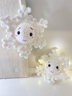 two white sheep made out of yarn sitting next to each other