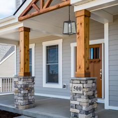 a front porch with stone pillars and columns on each side, along with an orange sign that reads metal buildings